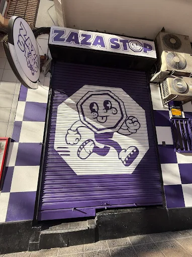 Fachada de ZazaStop con persiana morada y mascota